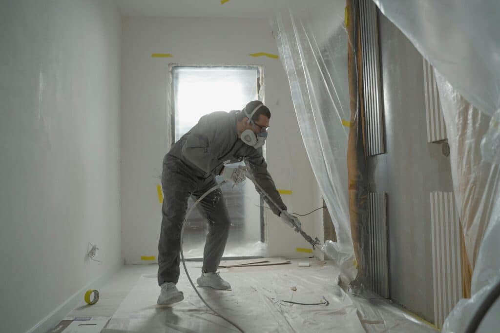 Man in safety helmet inspecting basement waterproofing project